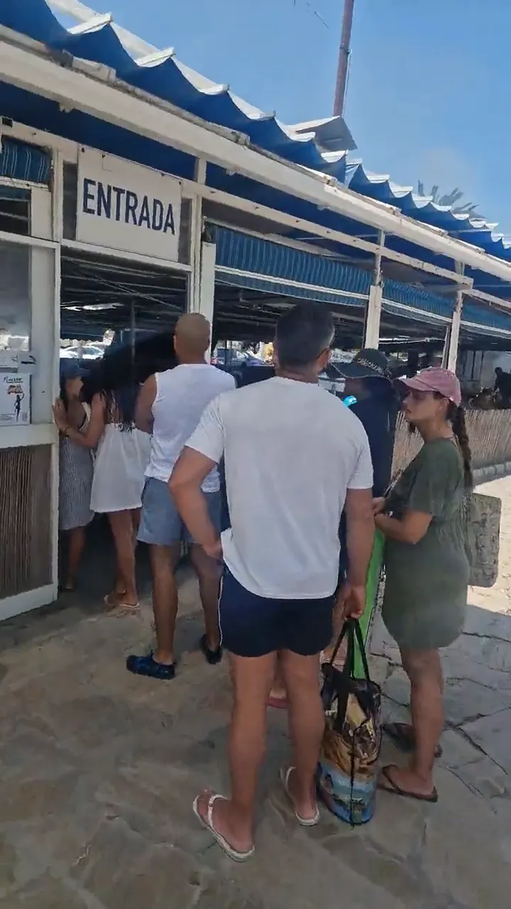 A long queue of people waiting outside the entrance to Chiringuito Ayo on Playa Burriana, Nerja